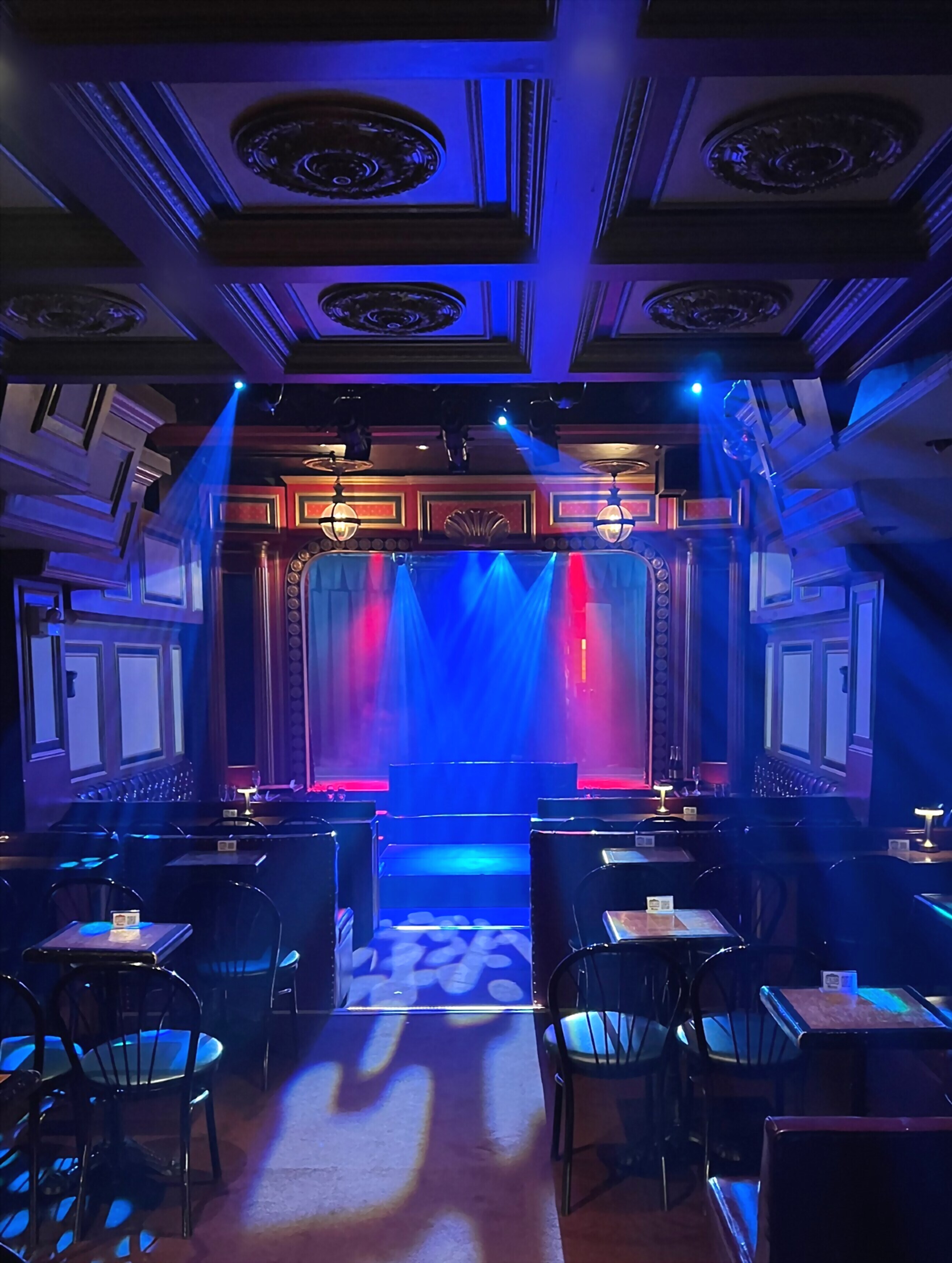 The stage at The Triad Theater under blue and red performance lighting